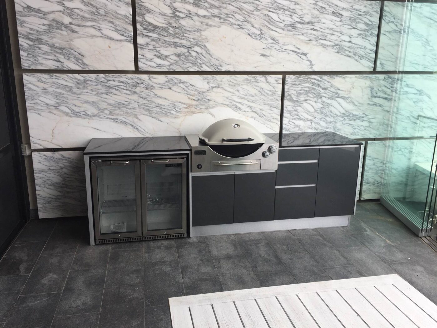 Full aluminium cabinets with titanium grey doors, and granite bench tops Sunco 2 Door fridge and a Weber Q BBQ. Location: