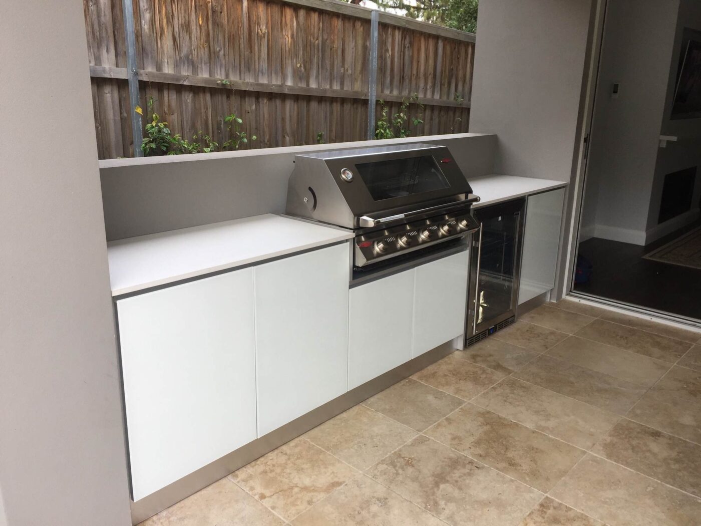 Full aluminium cabinets, with 5mm white tempered glass doors and 20mm Dekton bench tops in Nayla, complete with a Beefeater BBQ and Rhino Fridge.