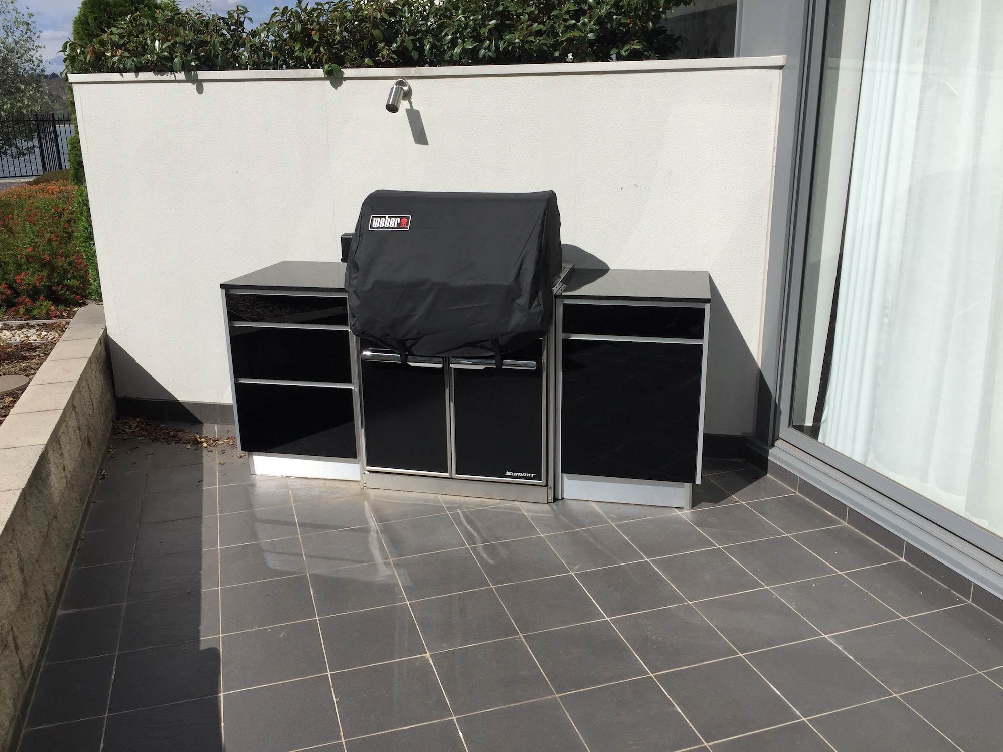 Full aluminium cabinets with 18mm black galaxy granite tops and 5mm tempered glass black doors, customer supplied their Weber Summit BBQ. Kingston, ACT